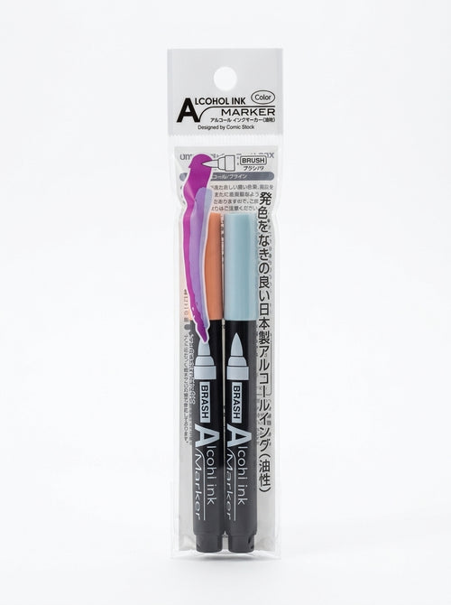 Two JapanoMono alcohol ink markers in blue, yellow, and gray, shown with vibrant ink tips for art and craft projects.