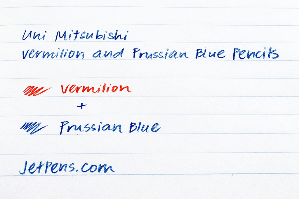 Uni Mitsubishi coloured pencils in vermillion and Prussian blue, featuring round shape and vibrant pigment, on textured paper.